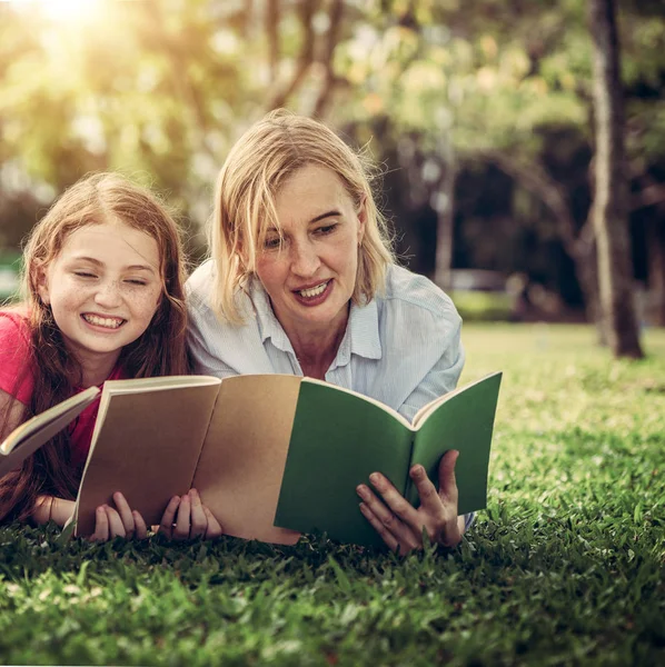 幸福的家庭一起读书 躺在公共公园的绿草上 小女孩的孩子学习与母亲在户外花园 教育和家庭生活方式 — 图库照片