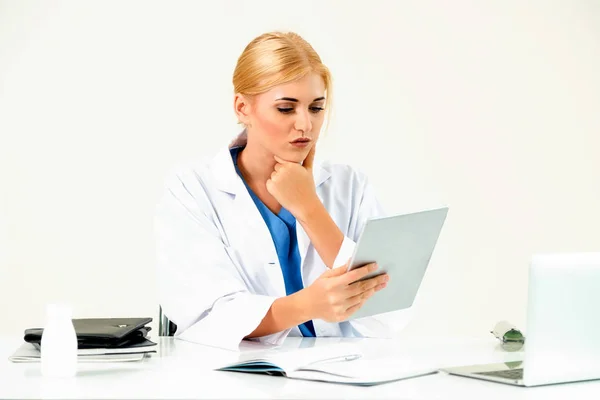 Woman doctor in hospital or healthcare institute working on medical report at office table.