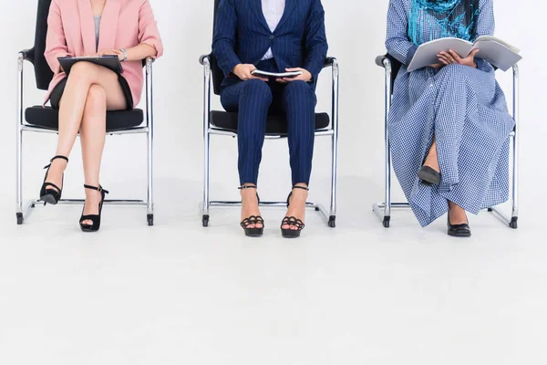 Business people job applicants sitting and waiting on chairs in office. Job application and recruitment concept.