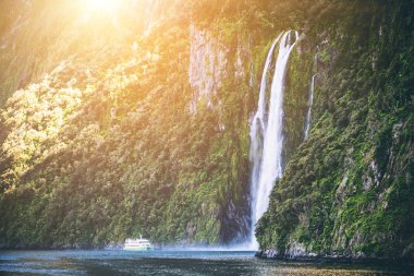 Gezi tekne turist kişi taşıyan büyük şelale Milford ses yaklaşıyor. Güzel manzara seyir ile Fiordland Milli Parkı içinde South Island, Yeni Zelanda.
