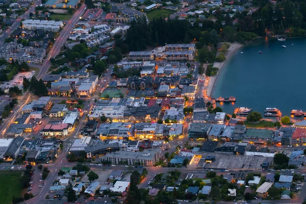 Aerial view of houses, business district street at night in the city center of Queenstown, New Zealand \'s South Island. Real estate, housing and land business.