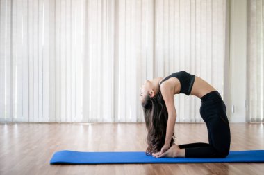 Genç kadın bir kapalı spor salonu stüdyo bulunduğu Yoga pratik. Sağlıklı ve sağlıklı yaşam yaşam tarzı kavramı.