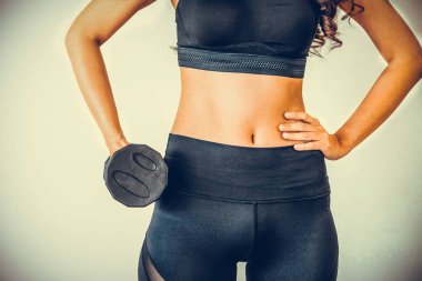 Sportif kadın egzersiz halter açık arka plan ile. Sağlıklı yaşam tarzı ve egzersiz.