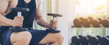 Kaslı adam vücut fitness spor salonu Eğitim dumbbells ile. Sağlıklı yaşam tarzı ve vücut geliştirme kavramı.