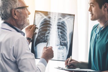 Hasta göğsünün x Ray filmi ile çalışan doktorlar.