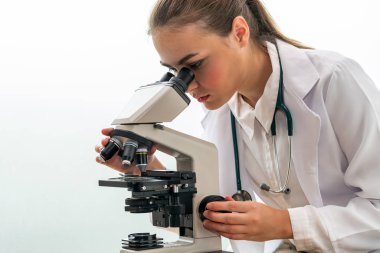 Hastane laboratuvarında mikroskop kullanan doktor.