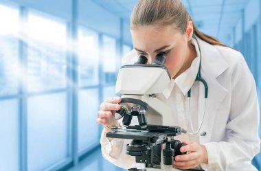 Bilim adamı araştırmacı laboratuvarda mikroskop kullanır