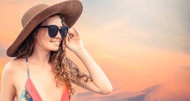 Renkli arka planda poz veren mayolu kadın.