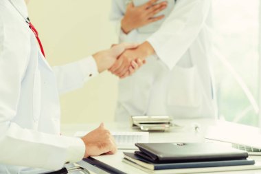 Hastanedeki doktor başka bir doktorla el sıkışıyor