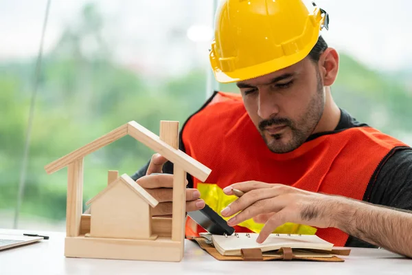 Ung man arkitekt eller ingenjör som arbetar vid skrivbordet. — Stockfoto