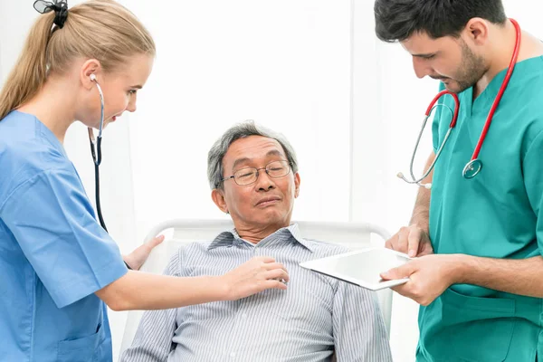 Equipo médico que atiende al paciente adulto mayor . — Foto de Stock