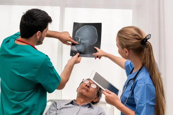 Команда врачей работает с рентгеновским снимком пациента . — стоковое фото