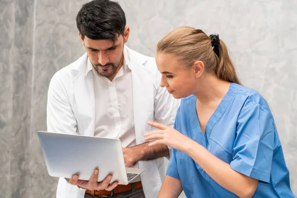 Médico y enfermera trabajando con computadora portátil . — Foto de Stock