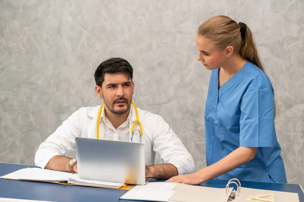 Médico y enfermera trabajando con computadora portátil . — Foto de Stock