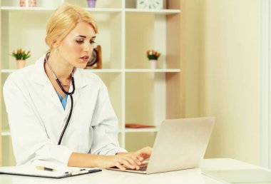 Hastane ofisinde çalışan genç kadın doktor.