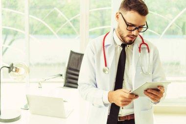 Hastanede tablet bilgisayar üzerinde çalışan doktor.