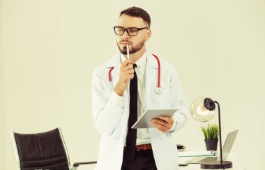 Hastanede tablet bilgisayar üzerinde çalışan doktor.