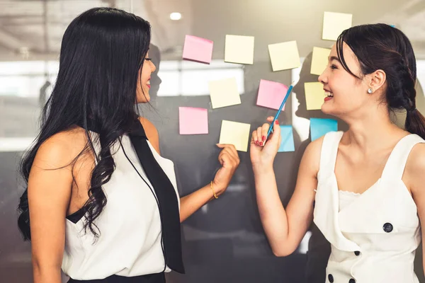 Twee zakenvrouwen praten en praten over creatief idee. — Stockfoto