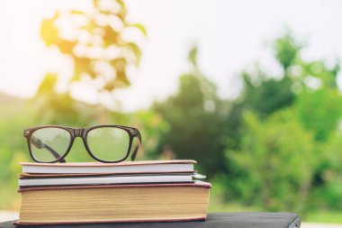 Doğa geçmişi olan kitaplar ve gözlükler.