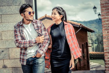 Şehirde sokakta yürüyen mutlu genç çift.