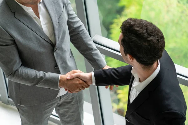 Businessmen handshake business deal in office.