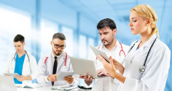 Médico que trabalha no hospital com outros médicos . — Fotografia de Stock