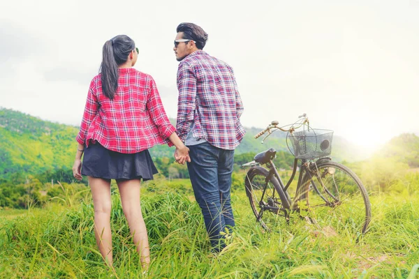 Feliz joven pareja montar en bicicleta en las colinas . —  Fotos de Stock