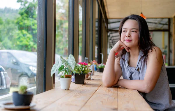 Jovem mulher asiática sentada em um café . — Fotografia de Stock