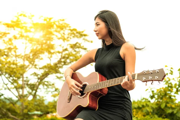 Mulher feliz toca guitarra com fundo natureza . — Fotografia de Stock