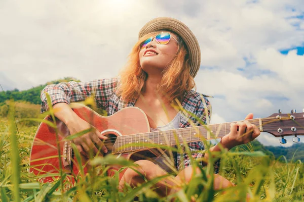 Glückliche Frau spielt Gitarre mit Naturhintergrund. — Stockfoto