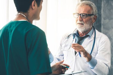 Başka bir doktorla çalışan kıdemli erkek doktor.