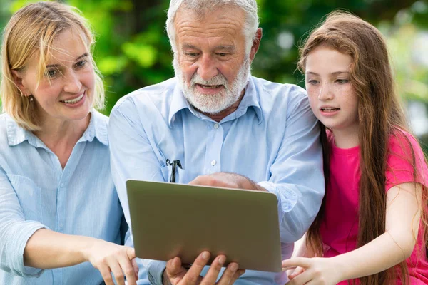 Família feliz usando computador portátil no parque público . — Fotografia de Stock