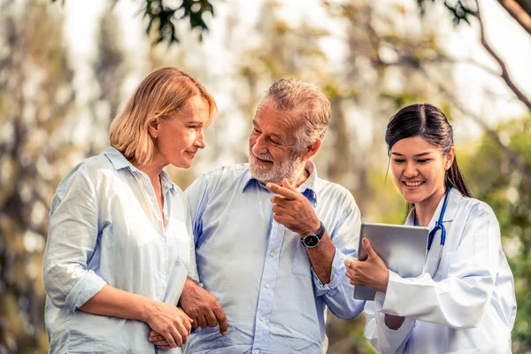 Pareja mayor hablando con enfermera o cuidador . — Foto de Stock