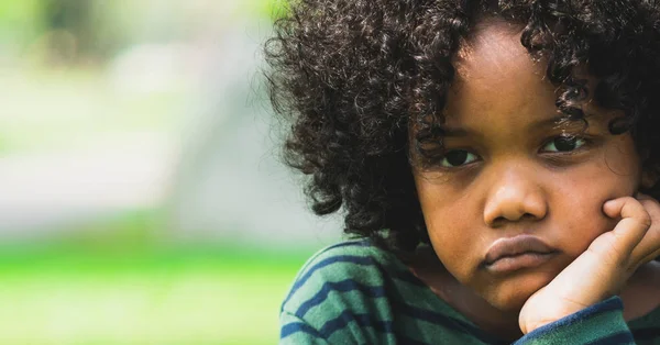 Unhappy little african american kid in the park. — Stock Photo, Image