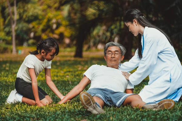 Doctor ayudando a un anciano desmayado en el suelo . — Foto de Stock