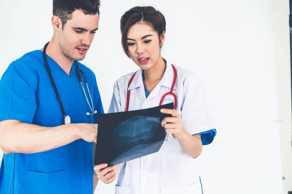 Médicos que trabajan con radiografías de la cabeza del paciente . — Foto de Stock