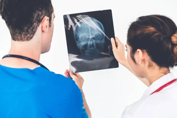 Doctors working with x ray film of patient head. — Stock Photo, Image