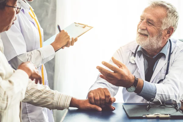 Senior doctor talking to patient in the hospital.