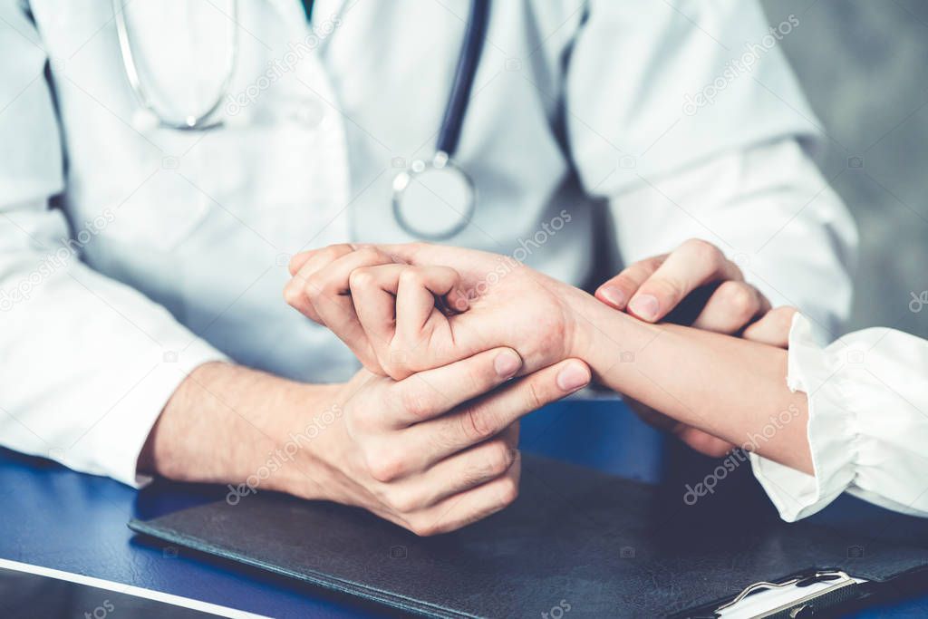 Young doctor examining patient in hospital office.