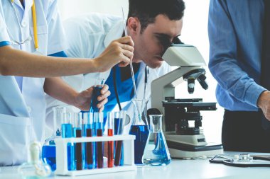 Kimya laboratuvarında çalışan bir grup bilim adamı.