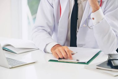 Doktor hastanede evrak ile çalışıyor. 