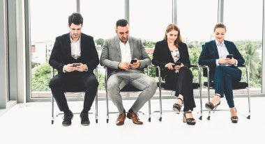 Cep telefonu kullanan iş kadınları ve işadamları.