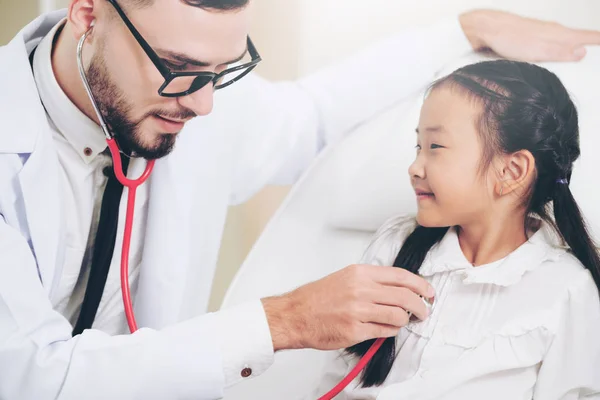 Médico examinando pequeño niño feliz en el hospital . — Foto de Stock