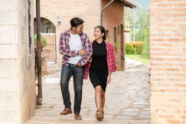 Şehirde sokakta yürüyen mutlu genç çift.