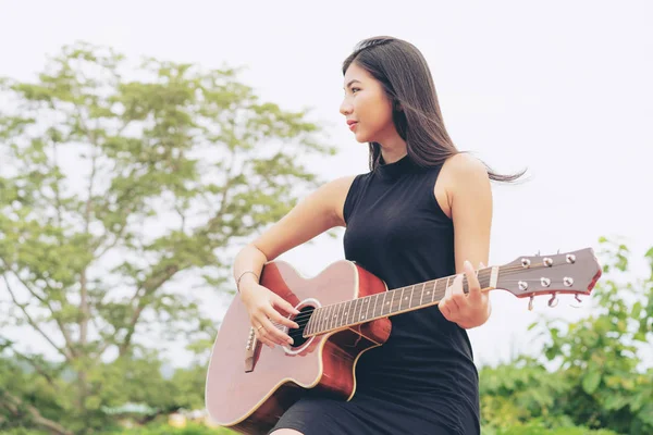 Mulher feliz toca guitarra com fundo natureza . — Fotografia de Stock