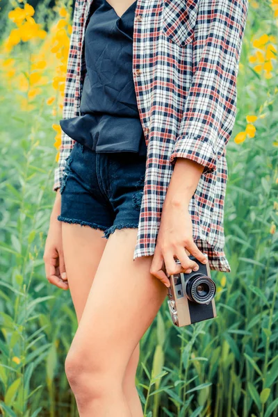 Young woman tourist holds retro style camera. — Stock Photo, Image