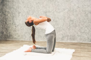 Evde oturma odasında halı üzerinde genç kadın yoga. 