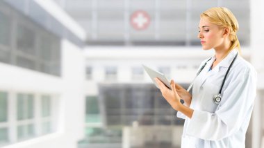 Hastanede tablet bilgisayar kullanan bir doktor..