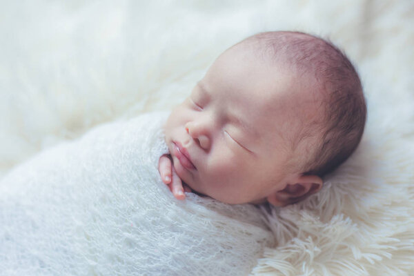 Adorable newborn baby sleeping in cozy room.