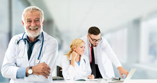 Dokter werkzaam in het ziekenhuis met andere artsen. — Stockfoto